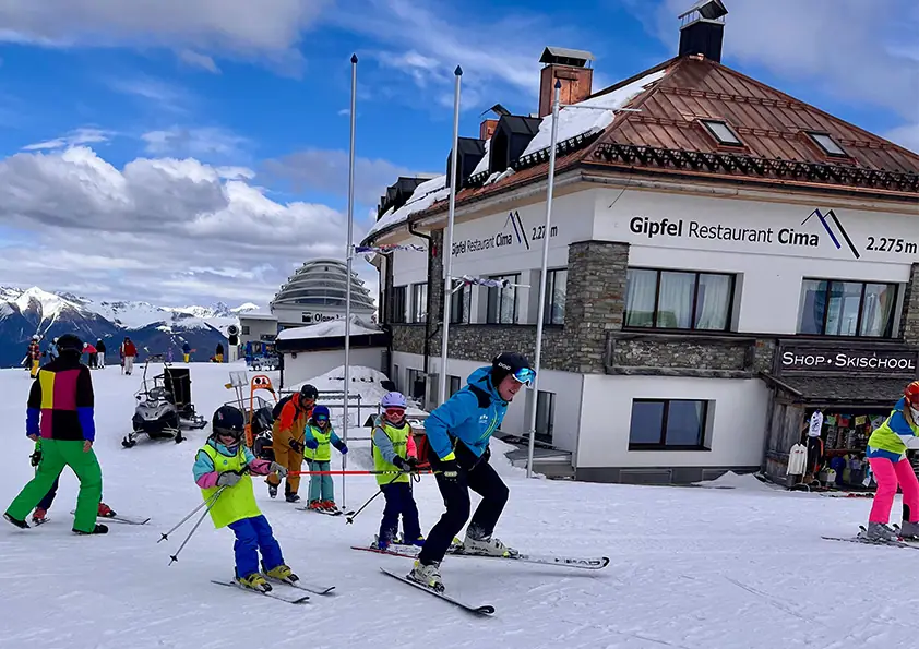 Kinder im Skikurs vor dem Gipfel Restaurant Cima auf 2.275 Metern