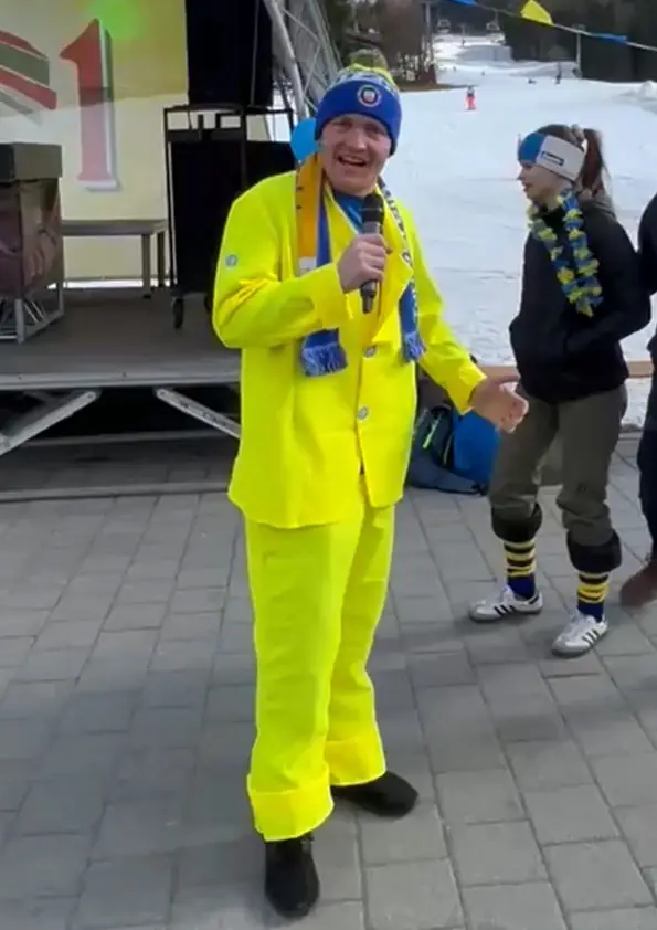 Person mit Mikrofon moderiert das Programm auf der Bühne